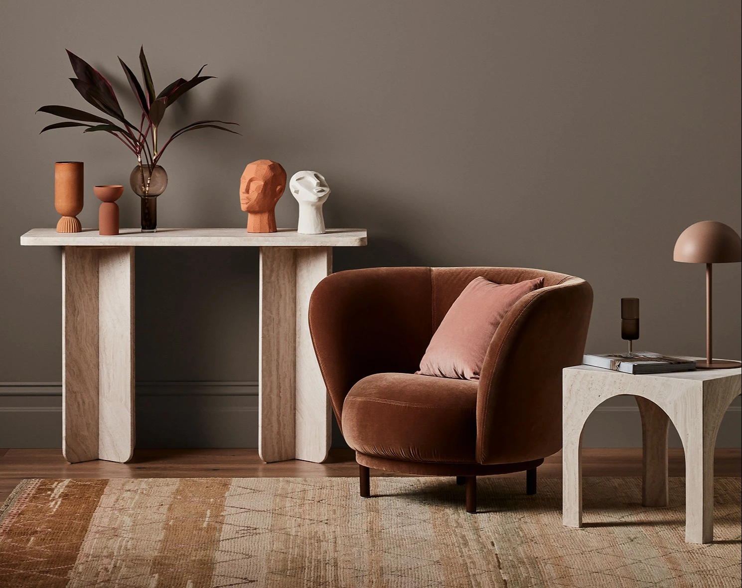 White and neutral themed living room with couch and buffet table against wall with decorative items.
