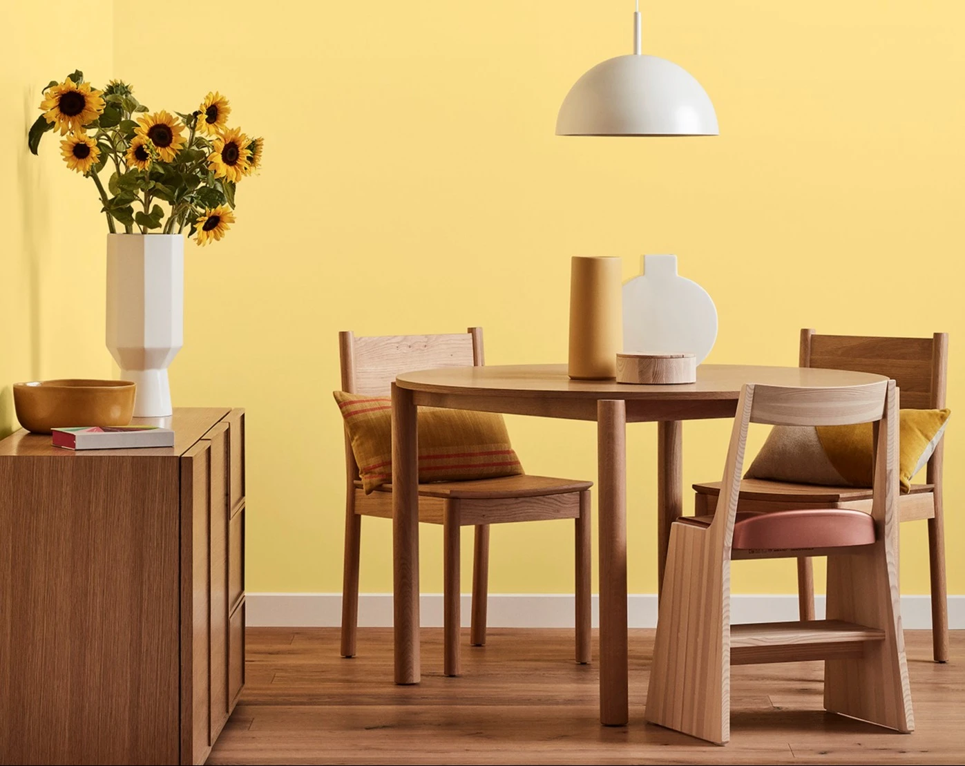 White and neutral themed living room with couch and buffet table against wall with decorative items.